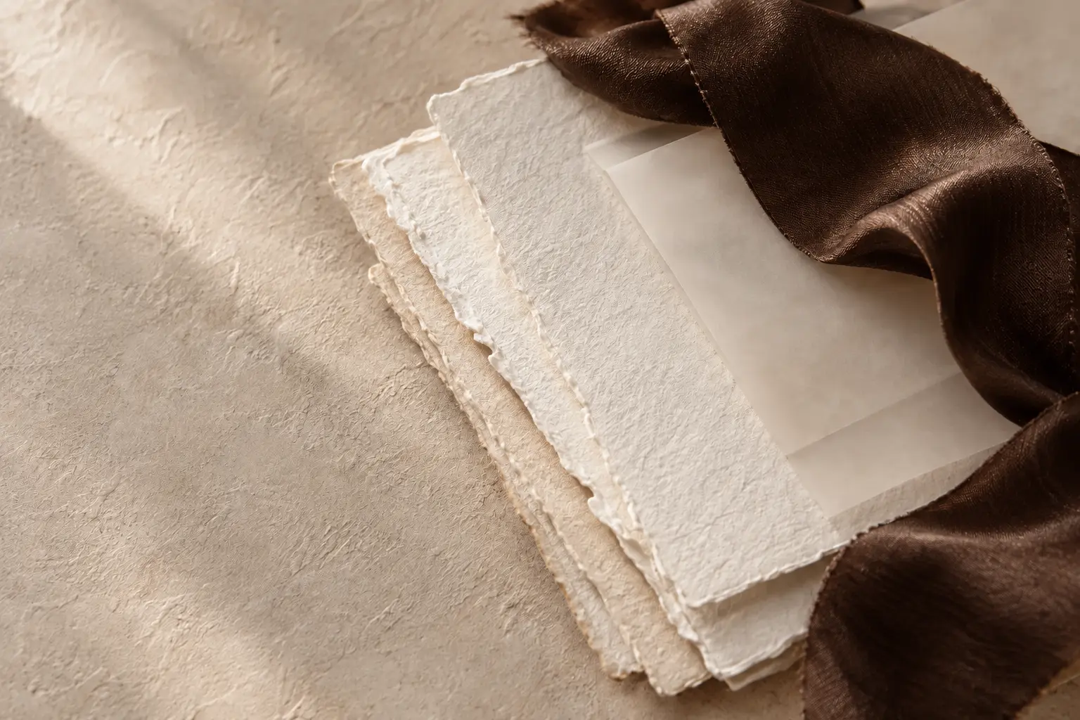 Handgeschept papier, kalkpapier en chocoladebruin zijden lint
